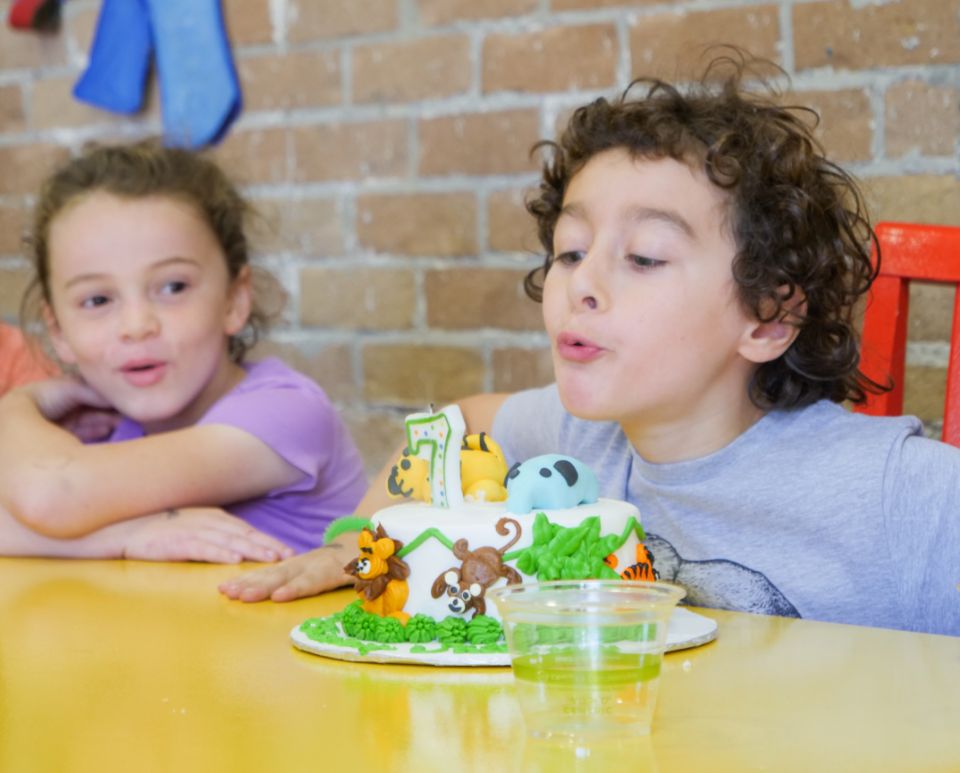 A child blowing out candles at a birthday party at Audubon Zoo